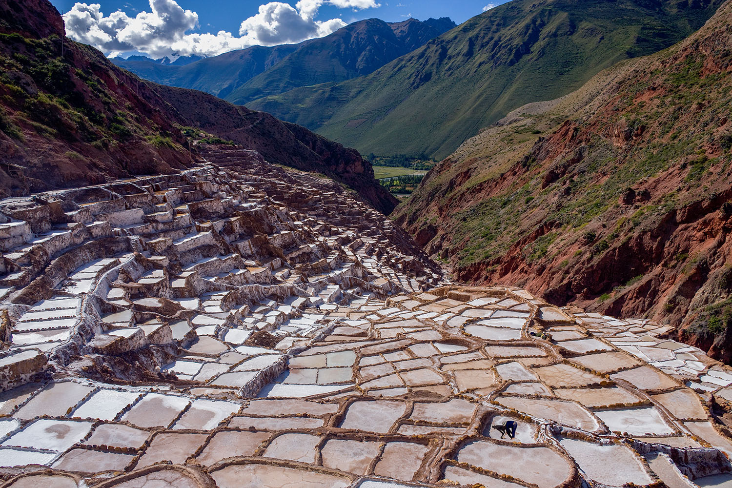 Maras Salt Mines in Peru’s Sacred Valley, with white salt terraces spreading across the mountainside and Andean peaks in the background.