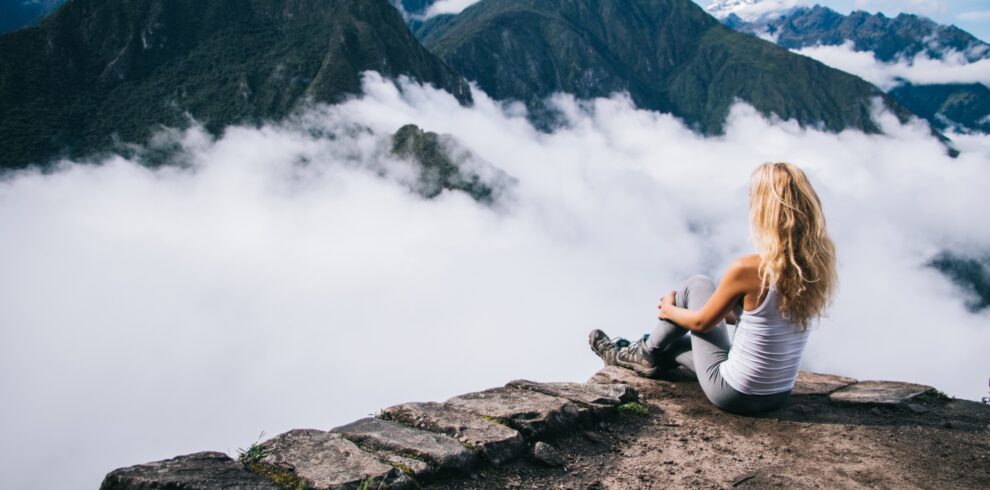 female tourist relaxing and admiring breathtaking view of Machu Picchu mountain