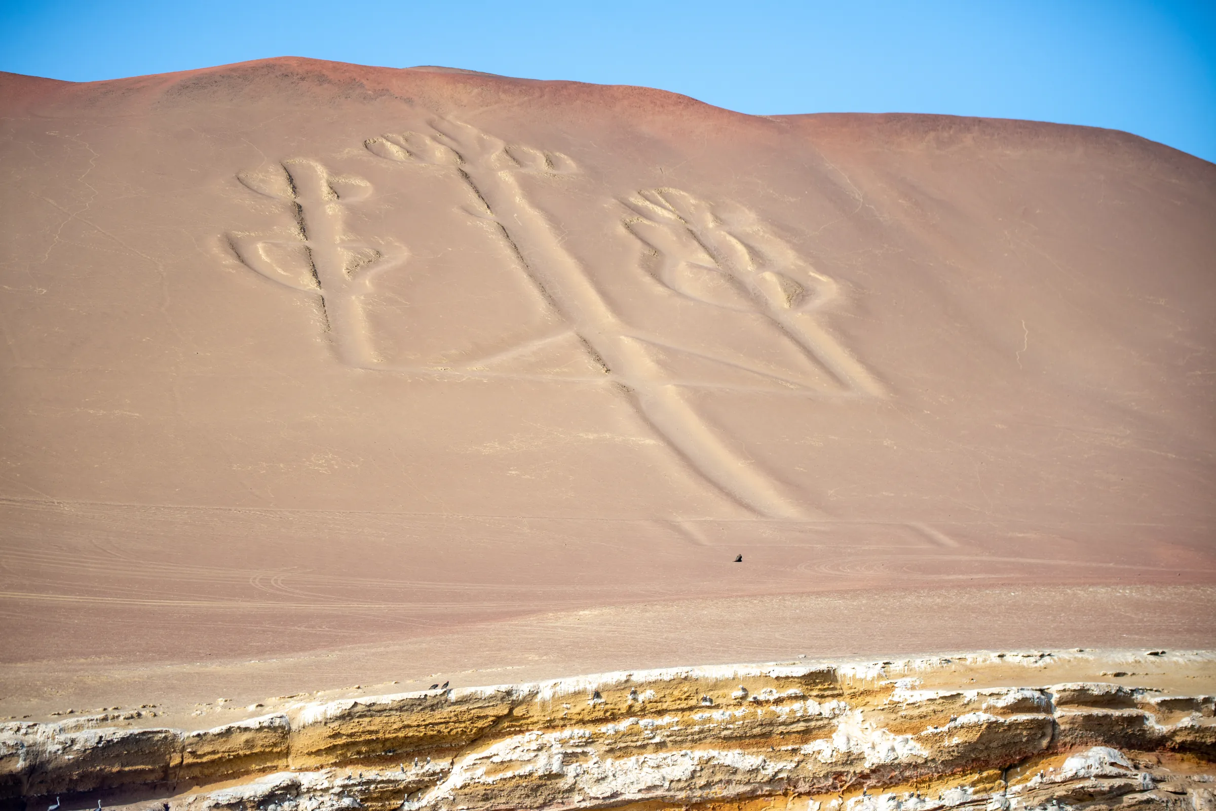 The Candelabra geoglyph carved into a desert hillside above Pisco Bay, Paracas, Peru